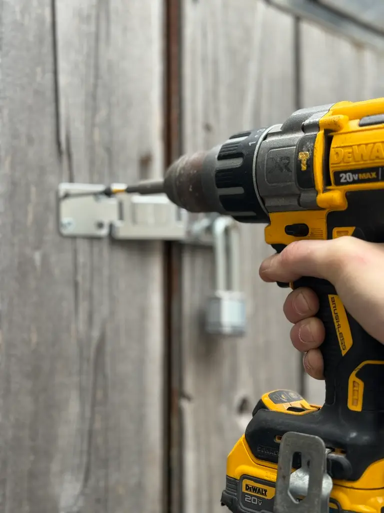 Technician drilling and installing new door hardware