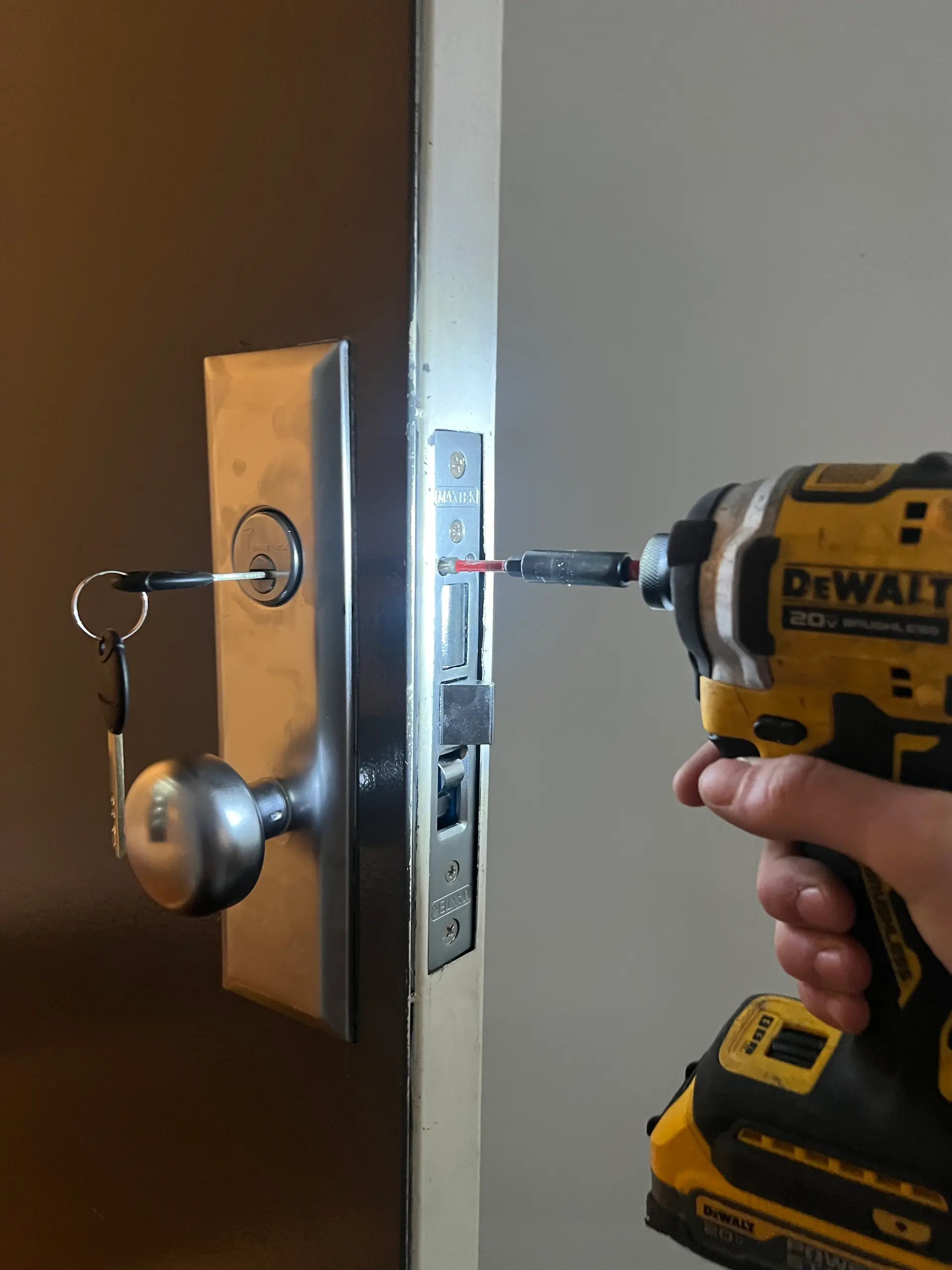 Locksmith installing a mortise lock cylinder and strike on a door